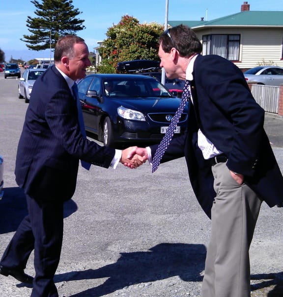John Key greets the families' lead solicitor Colin Smith before the meeting.