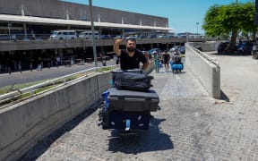 A passenger gestures as he pushes a loaded trolley after arrival at Rafic Hariri International Airport in Beirut on July 29, 2024. Airlines suspended flights to Lebanon on July 29, as diplomatic efforts were underway to contain soaring tensions between Hezbollah and Israel after deadly rocket fire in the annexed Golan Heights. (Photo by Anwar AMRO / AFP)