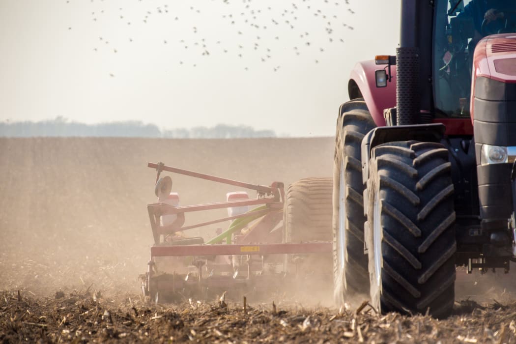 The tractor harvester working on the field.