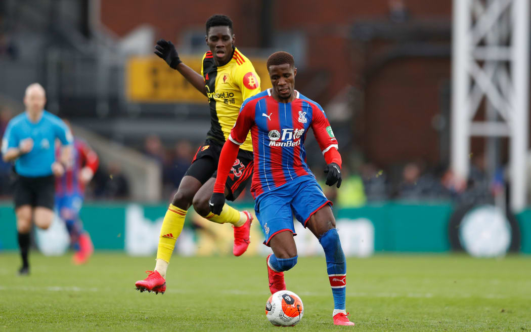 Wilfried Zaha of Crystal Palace runs past Ismaila Sarr of Watford