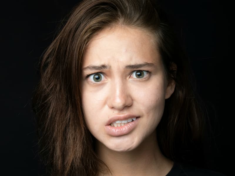 A woman makes an awkward facial expression.
