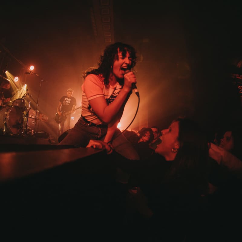 A woman yells into a microphone onstage.