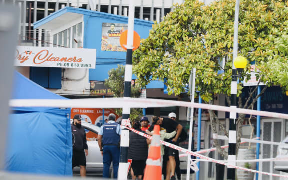 People speak to police at cordon at scene of fatal hit and run in Auckland