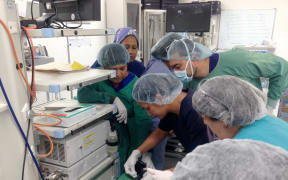 Dr Folototo Levai, Head of Medicine from Samoa is being taught a new skill by Dr Mai Ling Perman whilst ANZGITA nurse Karen Kempin (Dunedin) assists, and Dr David Motumanoa (Tonga) observes over shoulder.