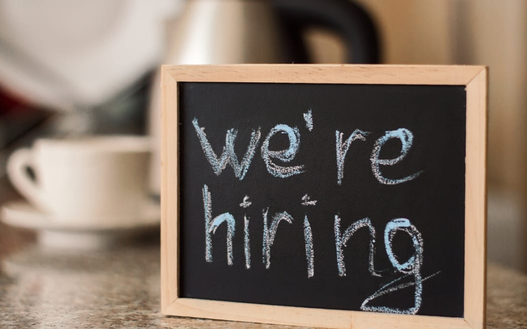 "We're hiring" sign at cafe.