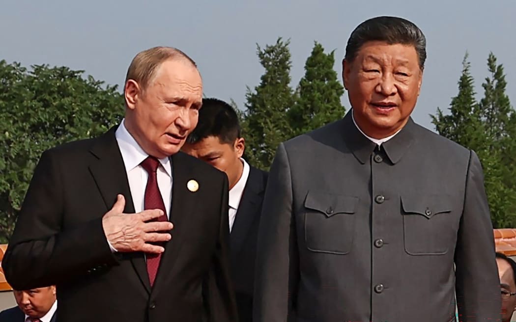 In this pool photograph distributed by the Russian state agency Sputnik, Russia's President Vladimir Putin (L) walks with China's President Xi Jinping before a military parade marking the 80th anniversary of victory over Japan and the end of World War II, in Beijing’s Tiananmen Square on September 3, 2025. (Photo by Alexander KAZAKOV / POOL / AFP)