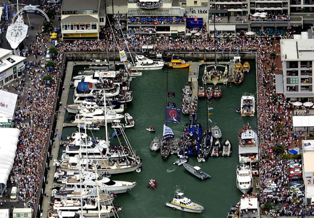 A large crowd lines Viaduct Basin to welcome Swiss challenger Alinghi SUI-64 (centre L), skippered by New Zealander Russell Coutts, and Team New Zealand NZL-82 (centre R), skippered by Dean Barker, after the fifth and final race of the 31st America's Cup 02 March 2003.
