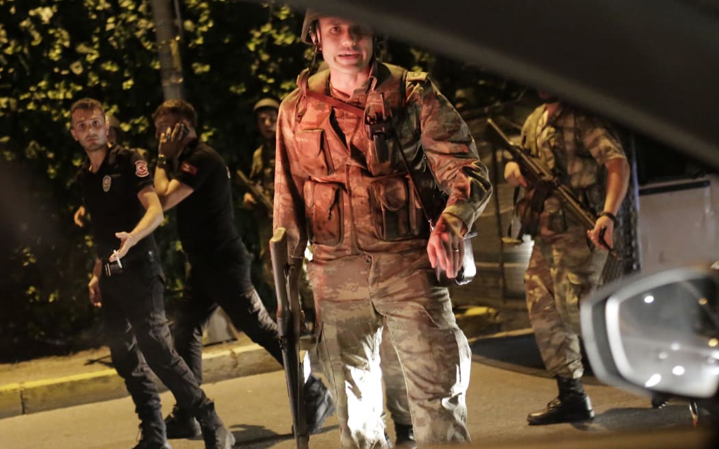 Turkish security officers detain Turkish police officers (in black) in Istanbul, during a security shutdown of the Bosphorus Bridge.