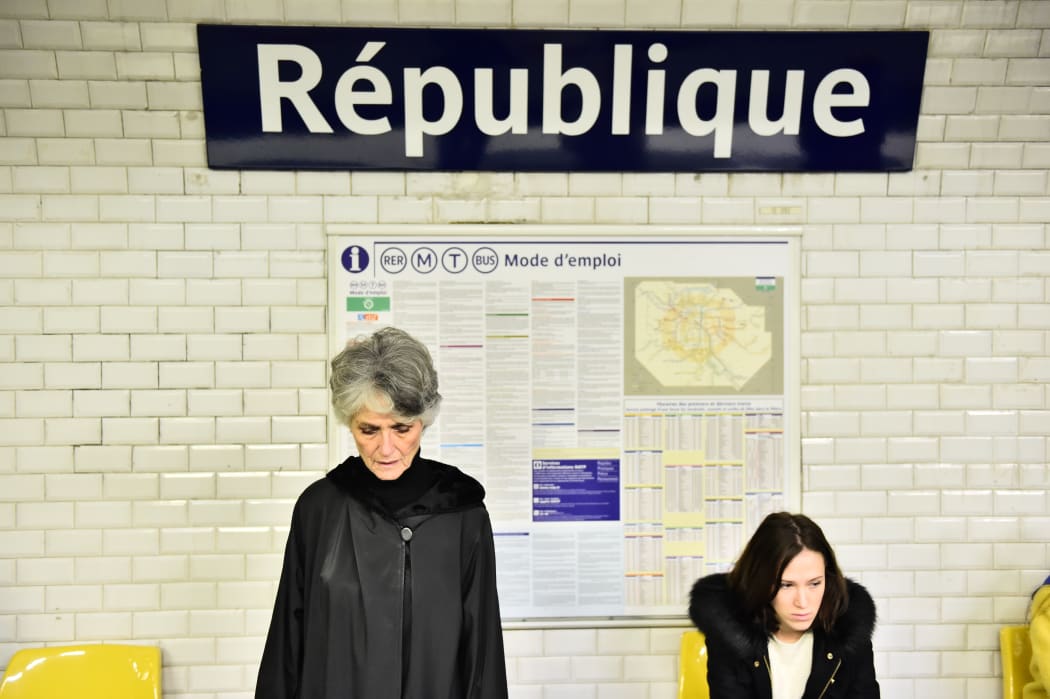 Metro passengers observe a minute of silence, on November 16, 2015 at Republique subway station in Paris, to pay tribute to victims of the attacks claimed by Islamic State which killed at least 129 people.