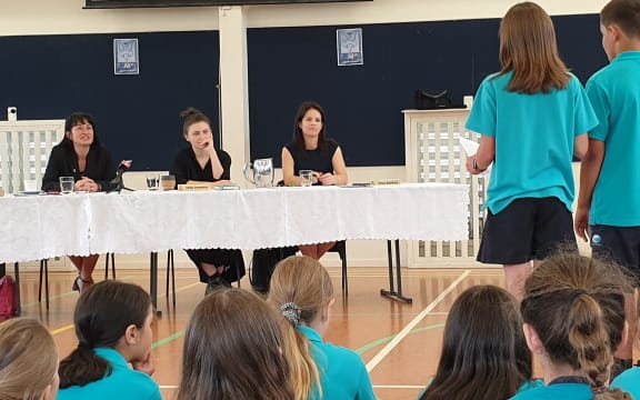 Labour Party MP Marja Lubeck, Green Party MP Chloe Swarbrick and National MP Erica Stanford listen earnestly to Long Bay Primary School year six students' petition.