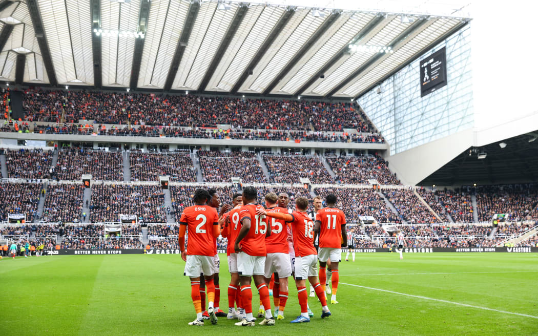Gabriel Osho of Luton Town celebrates with teammates after scoring his team's first goal during the Premier League match between Newcastle United and Luton Town at St. James Park.