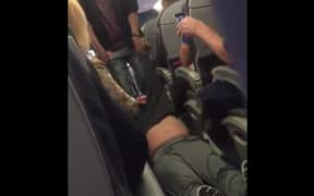 A screengrab from footage of the passenger being dragged from the plane.