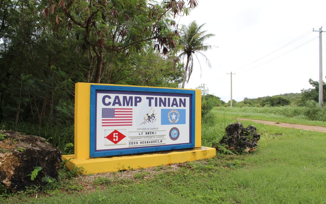 A sign that says "Camp Tinian," indicating a U.S. military camp on Tinian Island for joint exercises and projects.