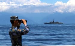 A soldier looks through binoculars during combat exercises and training of the navy of the Eastern Theater Command of the Chinese People’s Liberation Army (PLA) in the waters around the Taiwan Island, 5 August, 2022. T
