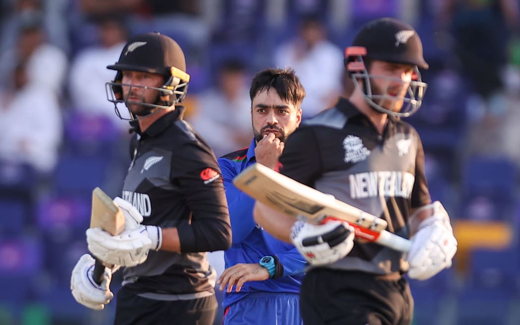 Rashid Khan (C) of Afghanistan reacts as captain Kane Williamson (R) and Devon Conway of the New Zealand BlackCaps.