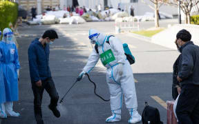 A patient who has recovered from COVID-19 receives disinfection before leaving a makeshift hospital converted from Shanghai Convention & Exhibition Center of International Sourcing in Shanghai, east China, April 9, 2022.