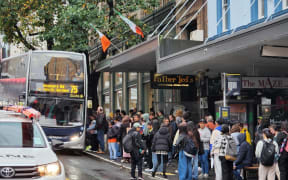 People queued up waiting for a bus to arrive on Wellesley Street on 9 May, 2023.