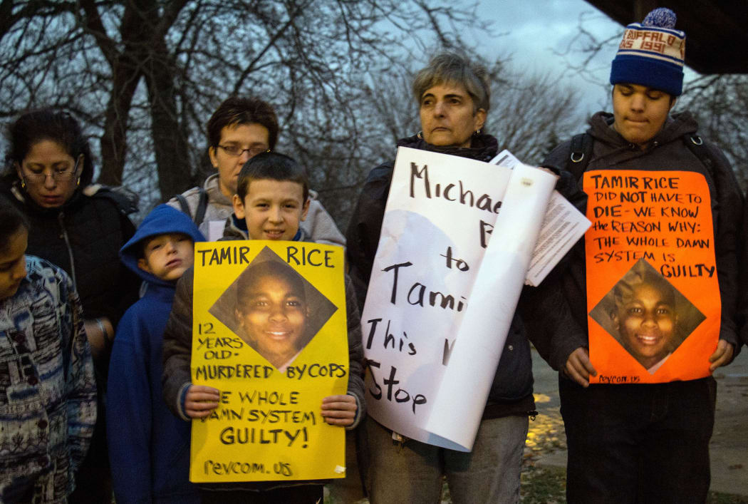 People display sigs at Cudell Commons Park in Cleveland, Ohio, during a rally for Tamir Rice.