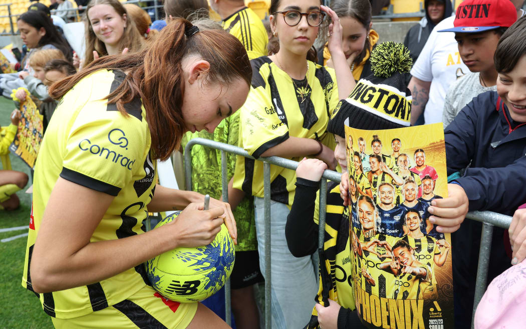 Wellington Phoenix player Mackenzie Barry signs autographs.