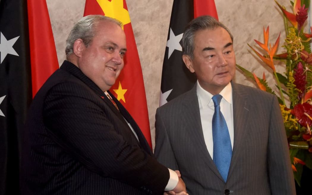 Papua New Guinea's Foreign Minister Justin Tkatchenko (left) shakes hands with China's Foreign Minister Wang Yi before their bilateral meeting in Port Moresby on April 20, 2024. [Andrew Kutan/AFP]