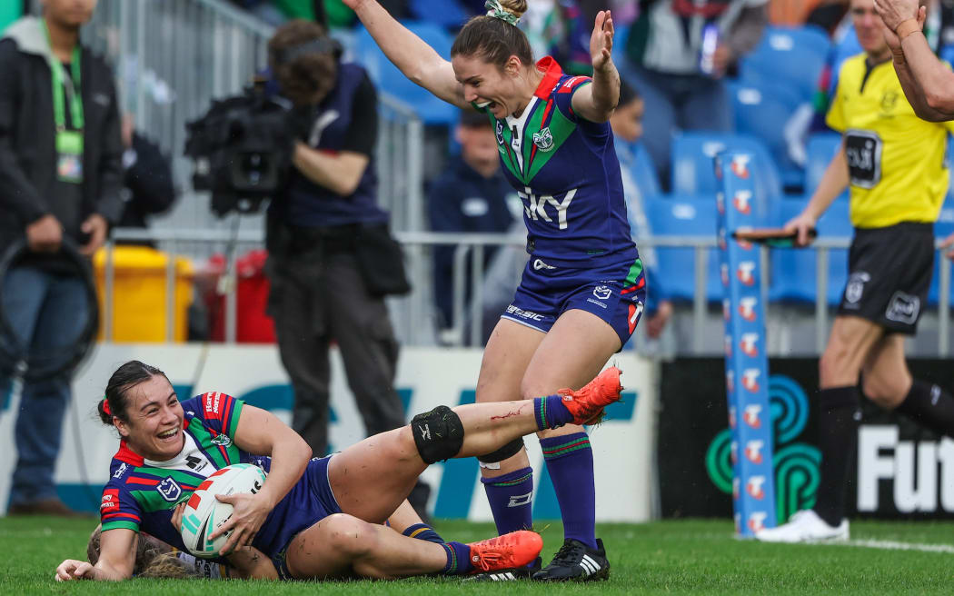 Tysha Ikenasio of the Warriors scores a try as Michaela Brake of the Warriors and Apii Nicholls (captain) of the Warriors cheer,,