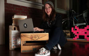 Anna Guenther, wearing sneakers, her laptop on a beer crate.