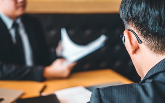 Senior manager reading a resume during a job interview employee young man meeting Applicant and recruitment concept