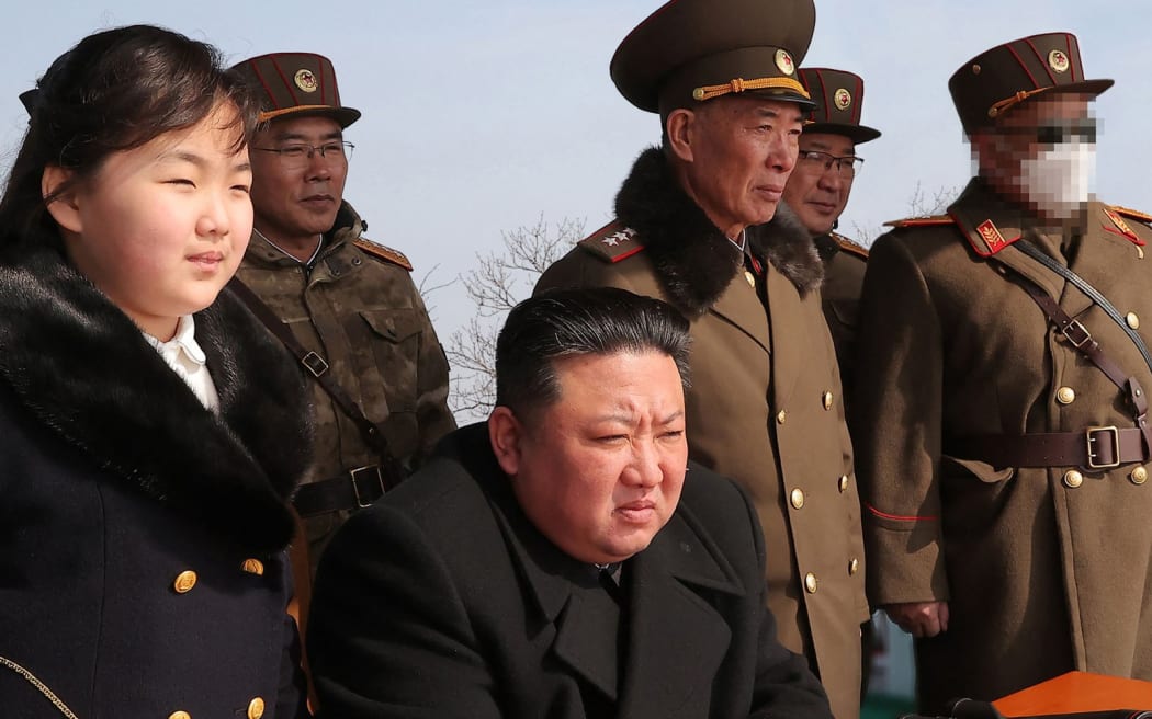 This recent picture released by North Korea's official Korean Central News Agency (KCNA) on March 20, 2023 shows North Korea's leader Kim Jong Un (C) and his daughter (L) observing a warhead missile launch exercise simulating a tactical nuclear attack in Cheolsan county, North Pyongan Province.