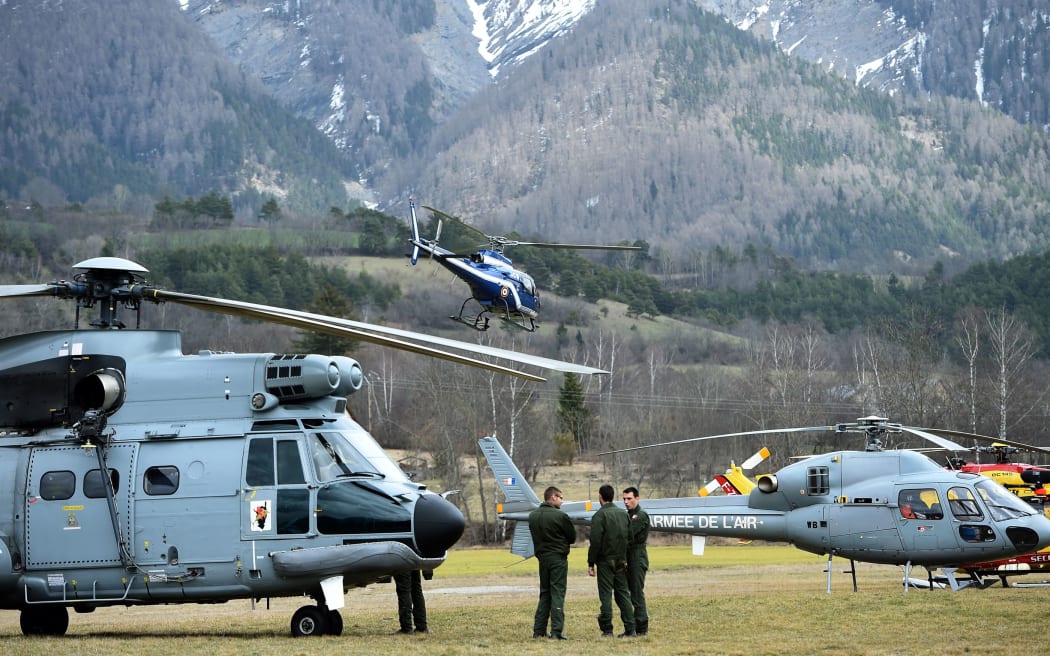 Rescue helicopters near the site of the crash in a remote mountain area.