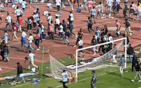 Security personnel try to control the crowd as Argentina's footballer Lionel Messi departs from Salt Lake Stadium during his GOAT Tour in Kolkata on December 13, 2025. Angry spectators broke down barricades and stormed the pitch at a stadium in India after football star Lionel Messi, who is on a three-day tour of the country, abruptly left the arena. As a part of a so-called GOAT Tour, the 38-year-old Argentina and Inter Miami superstar touched down in the eastern state of West Bengal early on December 13, greeted by a chorus of exuberant fans chanting his name. (Photo by Dibyangshu SARKAR / AFP)