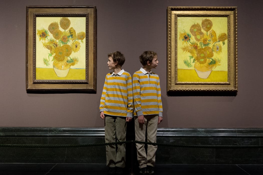 Identical twins Edgar and Gabriel with the sunflower paintings at London's National Gallery.
