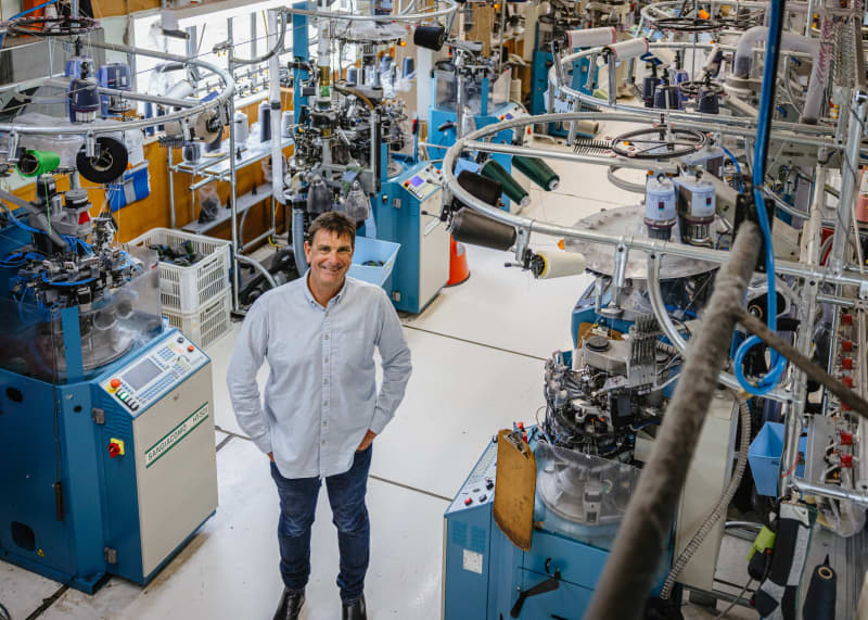 Norsewear owner Tim Deane stands between his sock-making mahcines at the factory in Norsewood, at the foot of the Ruahine ranges in southern Hawke’s Bay.
