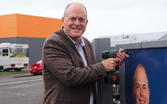 Todd Muller places the final screw in the new billboard in Napier