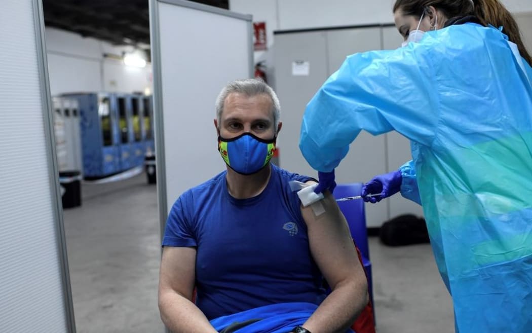 A health worker administers the Pfizer-BioNTech COVID-19 vaccine to a member of the Emergency Medical Services of Madrid (SUMMA) in Madrid on January 12, 2021.