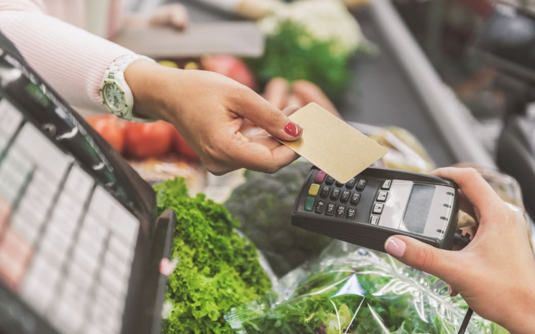 Woman is going to use contactless means of payment in supermarket. Close up of female hands holding necessary cash equipment