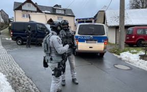German special police forces patrol and search the area in Bad Lobenstein, Thuringia, eastern Germany, on December 7, 2022 as part of nationwide early morning raids against members of a far-right "terror group" suspected of planning an attack on parliament. - More than 3,000 officers including elite anti-terror units took part in the early morning raids and searched more than 130 properties, in what German media described as one of the largest police actions the country has ever seen. The raids targeted alleged members of the "Citizens of the Reich" (Reichsbuerger) movement suspected of "having made concrete preparations to violently force their way into the German parliament with a small armed group", prosecutors said in a statement. (Photo by Fricke / NEWS5 / AFP)