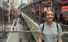 Lindsey Green standing in front of an escalator in Hong Kong.