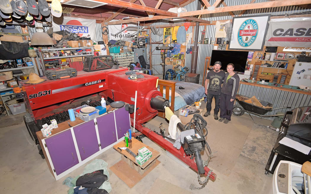 Tony Cowan and Sarah Jones sleep just metres from a bailing machine in a shed they’ve had to turn into a home following the cyclone. Picture by Liam Clayton