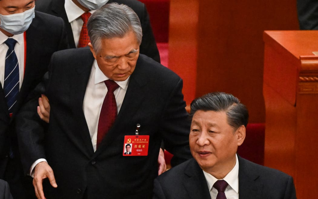 China's President Xi Jinping (R) talks to former president Hu Jintao as he is assisted to leave from the closing ceremony of the 20th Chinese Communist Party's Congress at the Great Hall of the People in Beijing on October 22, 2022. (Photo by Noel CELIS / AFP)