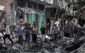 Palestinians check the rubble after the Israeli army withdrew from Nusairat in Gaza on June 8, 2024. The eight-month-long war of Israel in Gaza has devastated neighborhoods into rubles during the clashes with Hamas fighters. According to the United Nations and humanitarian agencies, nearly 1.7 million Palestinians have been displaced from their homes. Despite the growing pressure on the Israeli government led by Benjamin Netanyahu to accept the proposed truce and start a ceasefire, the Israeli war cabinet has insisted on going ahead with a more comprehensive military operation in the Gaza Strip. (Photo by Khames Alrefi / Middle East Images / Middle East Images via AFP)