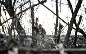 A serviceman from the 65th Separate Mechanized Brigade of the Land Forces of the Armed Forces of Ukraine is standing on the outskirts of Robotyne in the Zaporizhzhia region, southeastern Ukraine, on February 21, 2024. (Photo by Ukrinform/NurPhoto) (Photo by Dmytro Smolienko / NurPhoto / NurPhoto via AFP)
