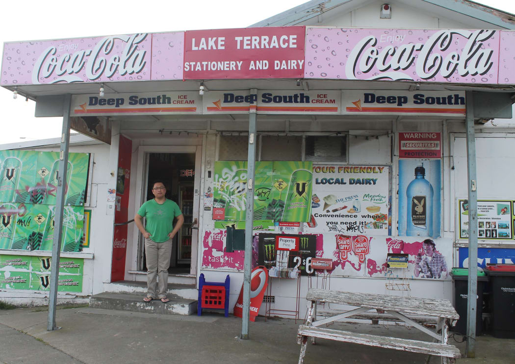A photo of Adam Du in front of the Burwood dairy he has worked for three years. It was robbed in August.