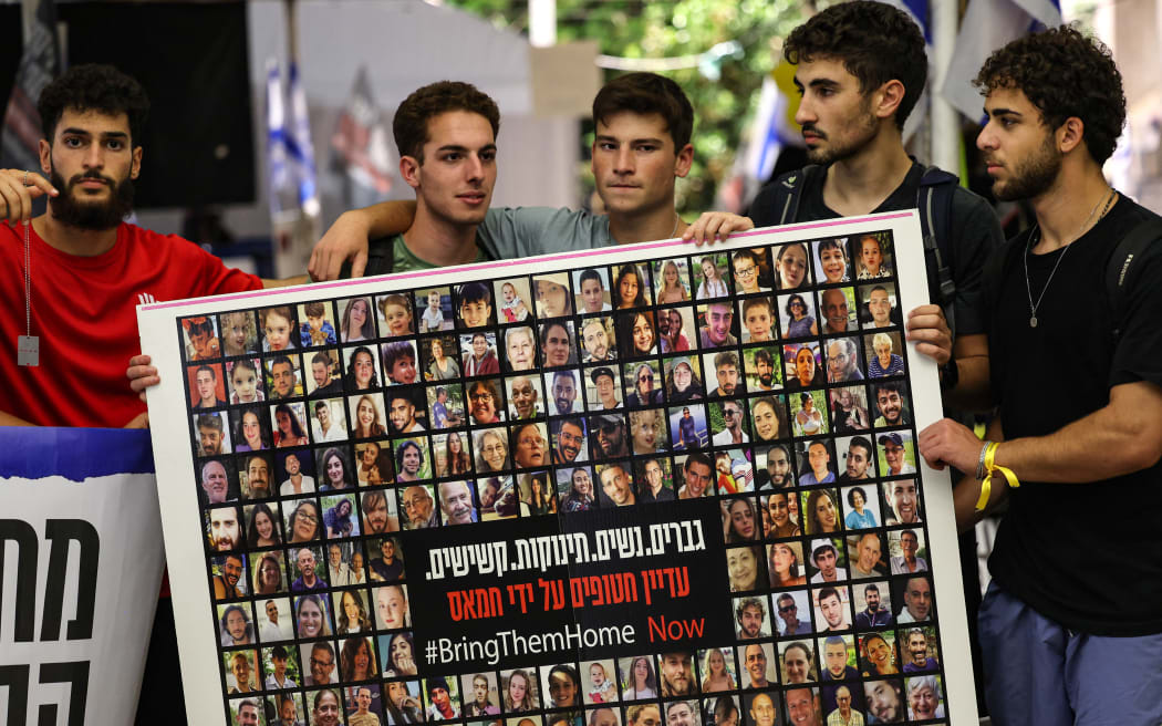 Relatives, friends and supporters of Israeli hostages held in Gaza since the October 7 attack by Hamas militants in southern Israel, hold placards and images of those taken during a protest for their release in Tel Aviv on November 22, 2023. (Photo by AHMAD GHARABLI / AFP)