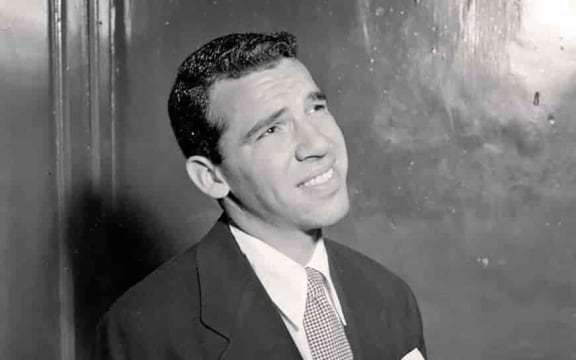 Drummer Buddy Rich wearing a suit and looking up