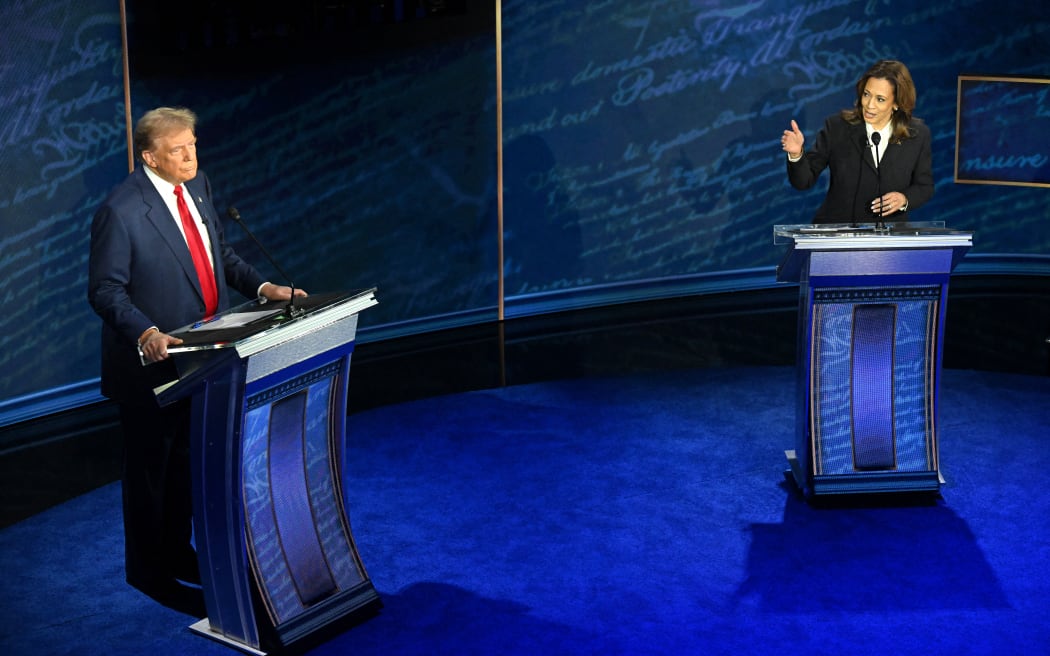 US Vice President and Democratic presidential candidate Kamala Harris (R) speaks as former US President and Republican presidential candidate Donald Trump listens during a presidential debate at the National Constitution Center in Philadelphia, Pennsylvania, on September 10, 2024. (Photo by SAUL LOEB / AFP)