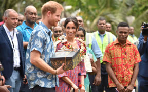 Britain's Prince Harry and his wife Meghan, Duchess of Sussex receive a gift from the University of the South Pacific in Suva.