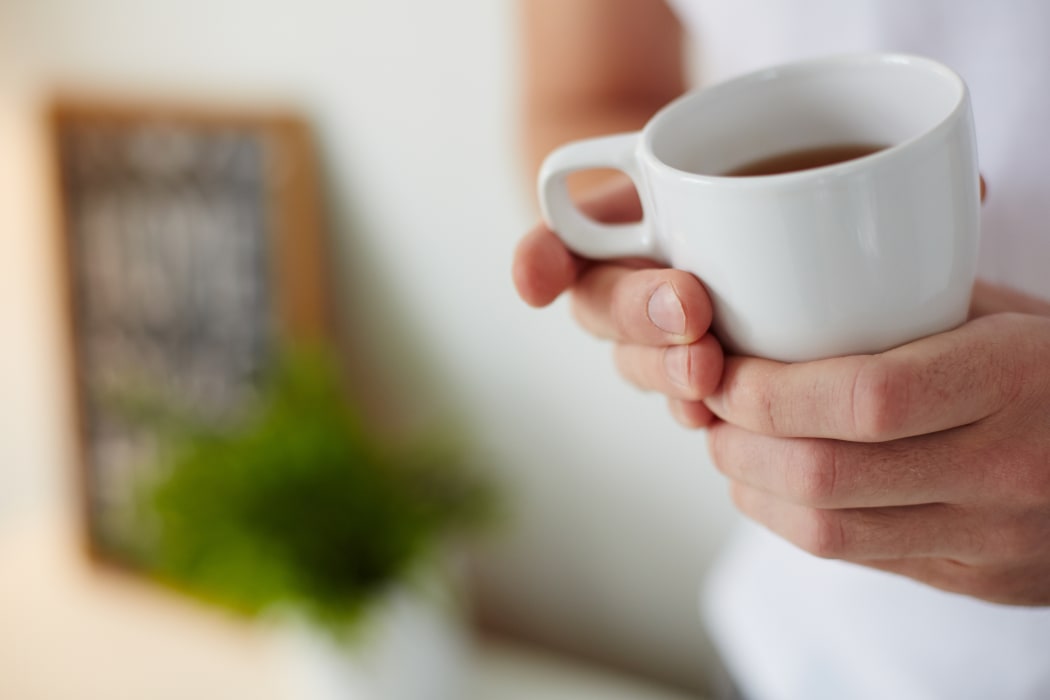 Image of cup of tea in male hands