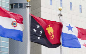The flag of the Independent State of Papua New Guinea (centre) flying at United Nations headquarters in New York.14 July 2016 United Nations, New York