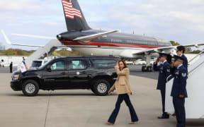 US Vice President and Democratic presidential candidate Kamala Harris steps off Air Force Two upon arrival at Charlotte Douglas International Airport with former US President and Republican presidential candidate Donald Trump's plane in the background in Charlotte, North Carolina, on 3 November 2024.