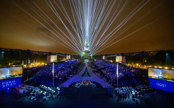 Overview of the Trocadero venue, with the Eiffel Tower looming in the background 
and lasers lighting up the sky, during the opening ceremony of the Paris 2024 Olympic Games on July 26, 2024 (Photo by François-Xavier MARIT / AFP)